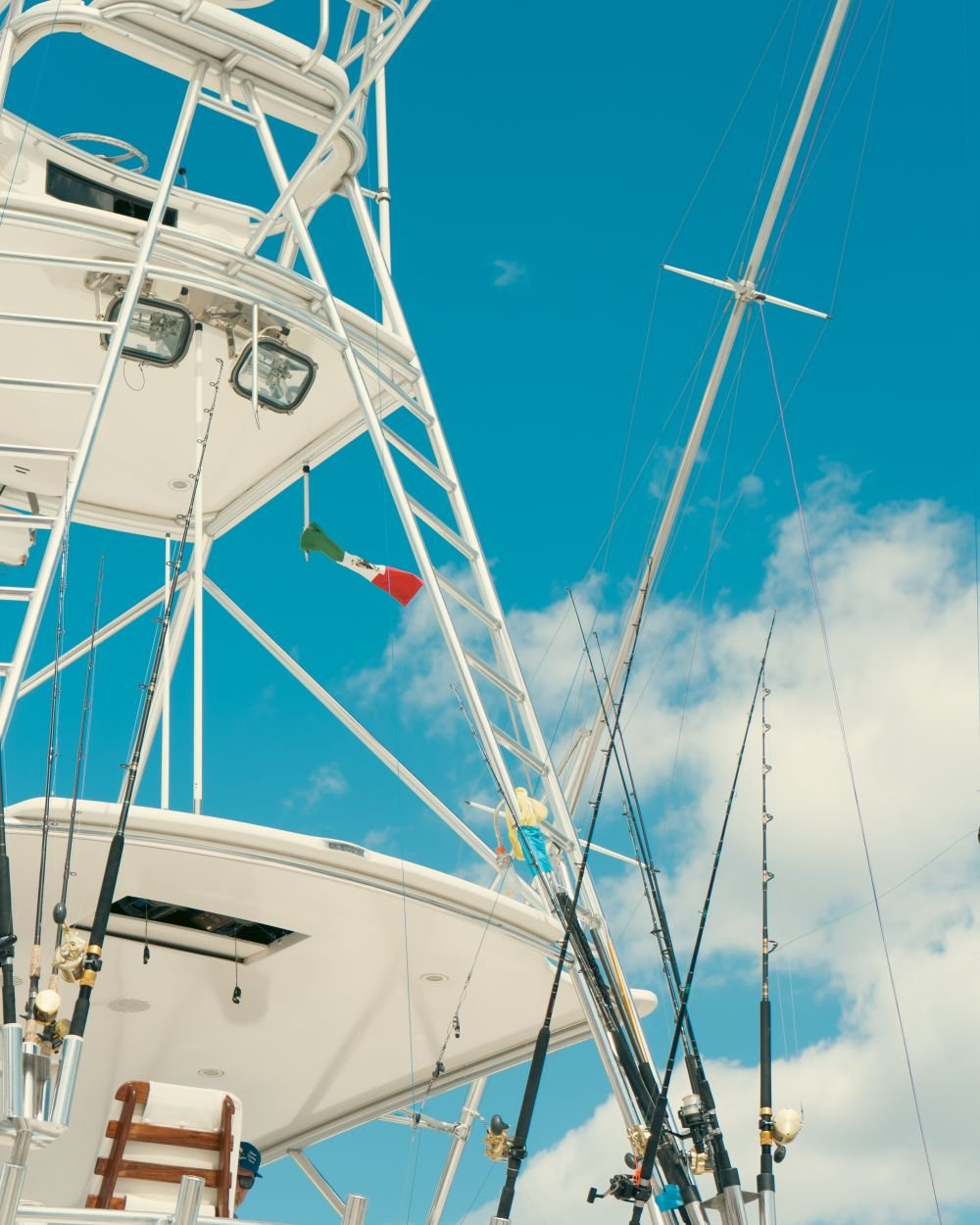 Sportfishing boat tower and outrigger rods under a Mexican flag