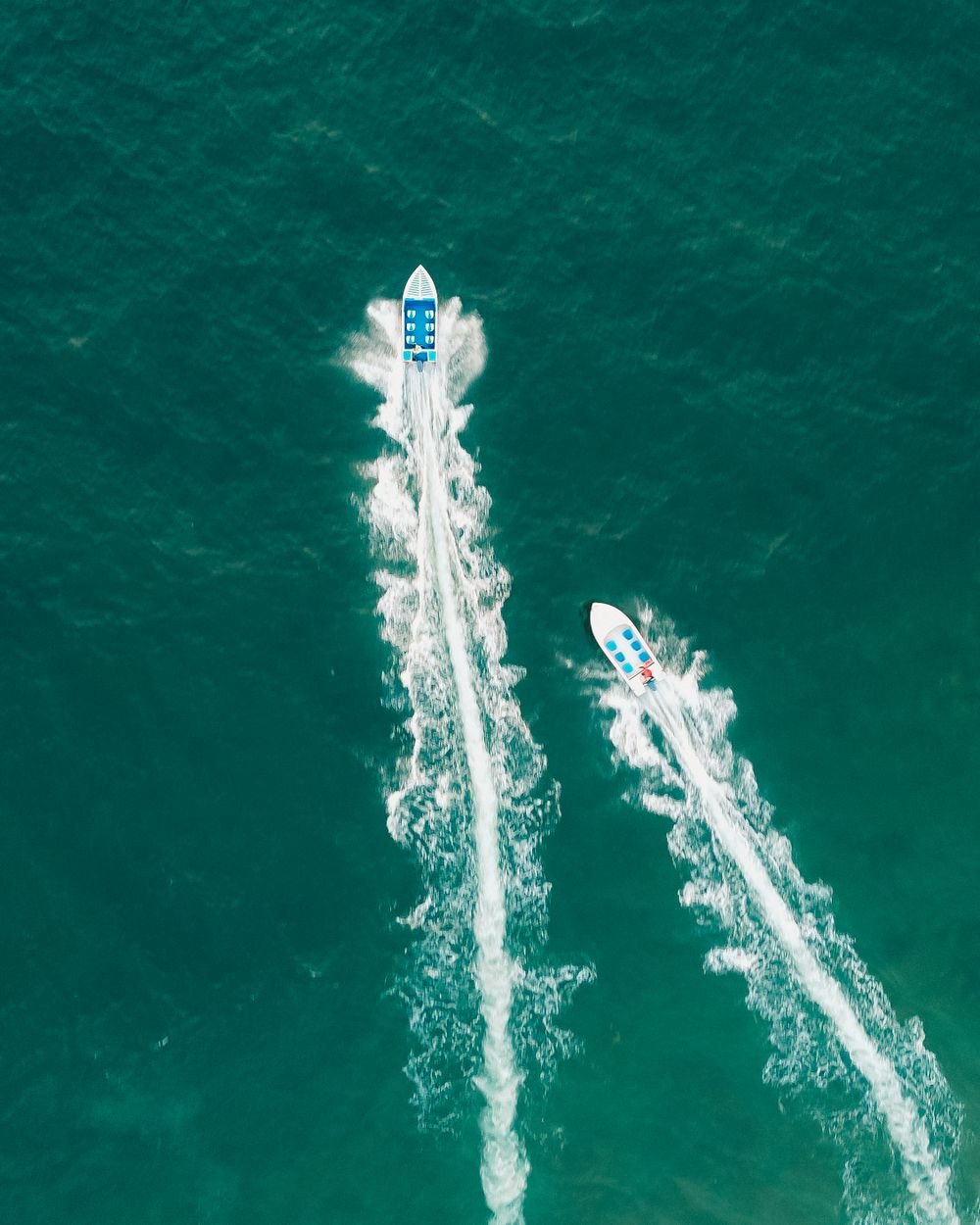 Two powerboats seen from above on open turquoise water