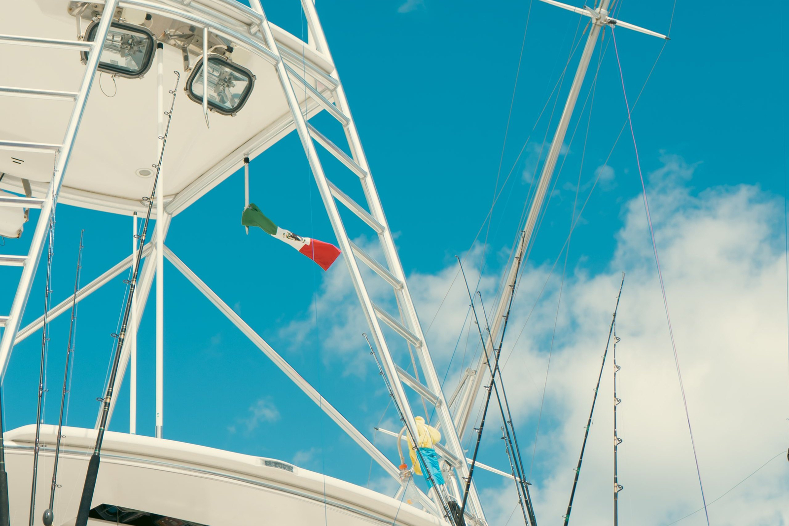 Sportfishing boat tower and outrigger rods under a Mexican flag