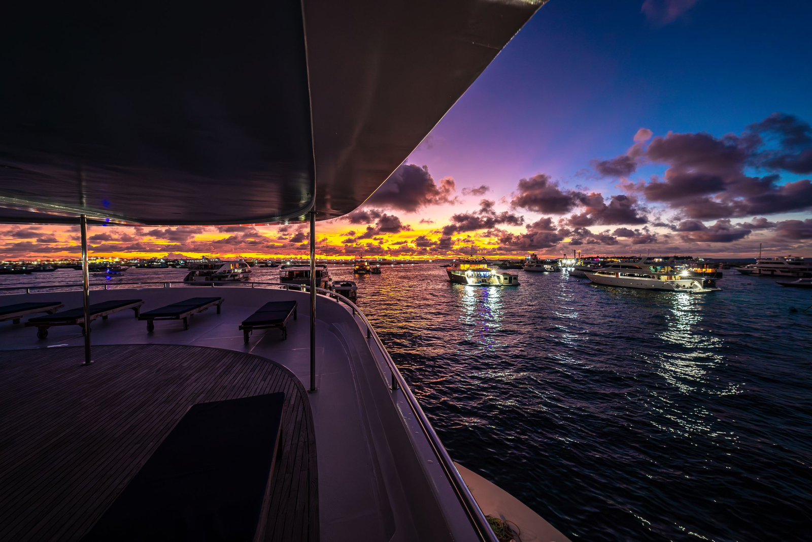A yacht at anchor as the sun goes down over open water