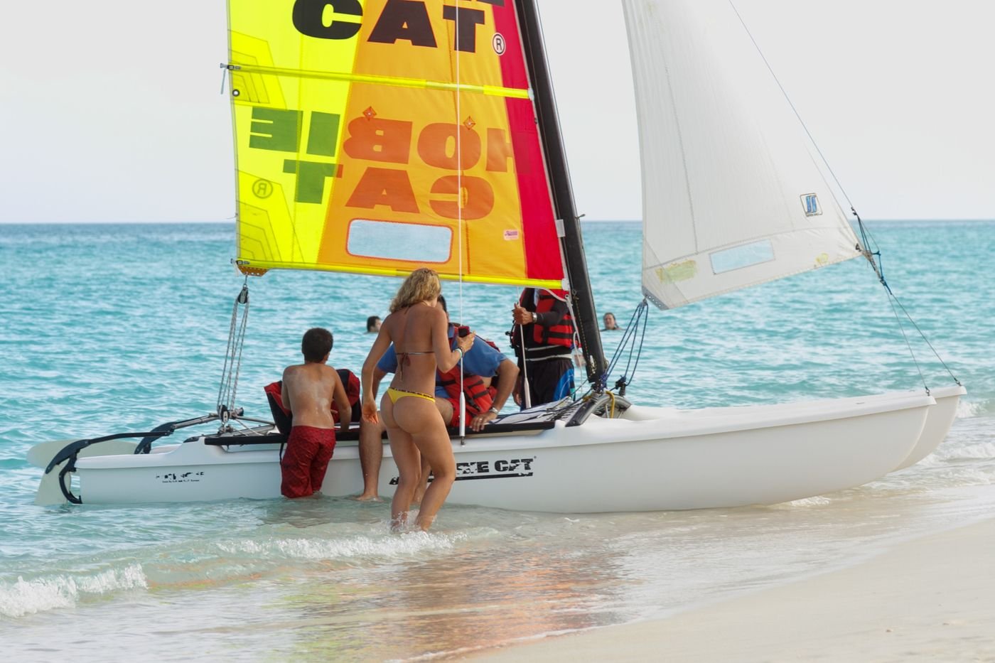 Group celebrating on a catamaran at golden hour