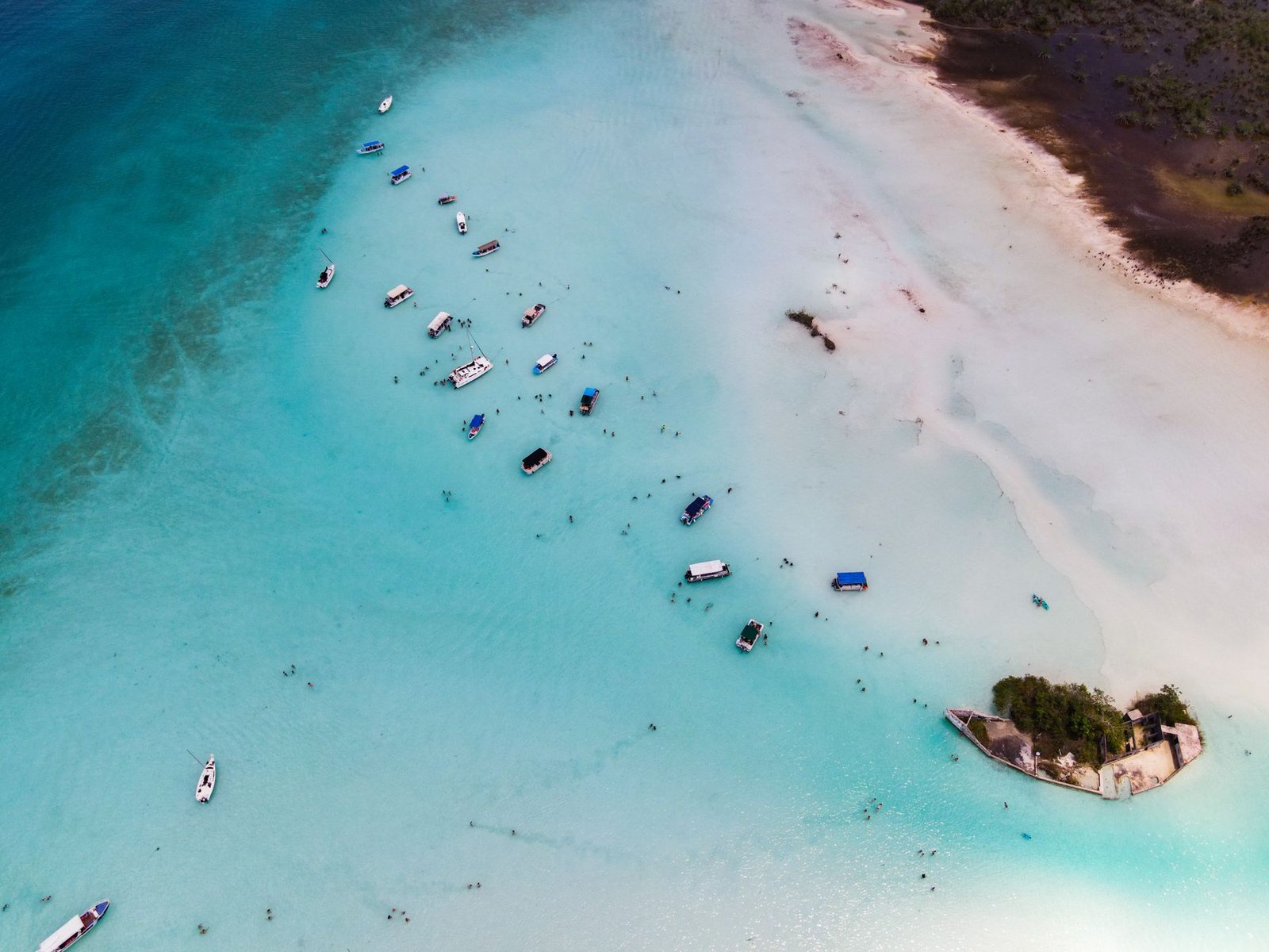 Guests jumping off a yacht bow into clear water