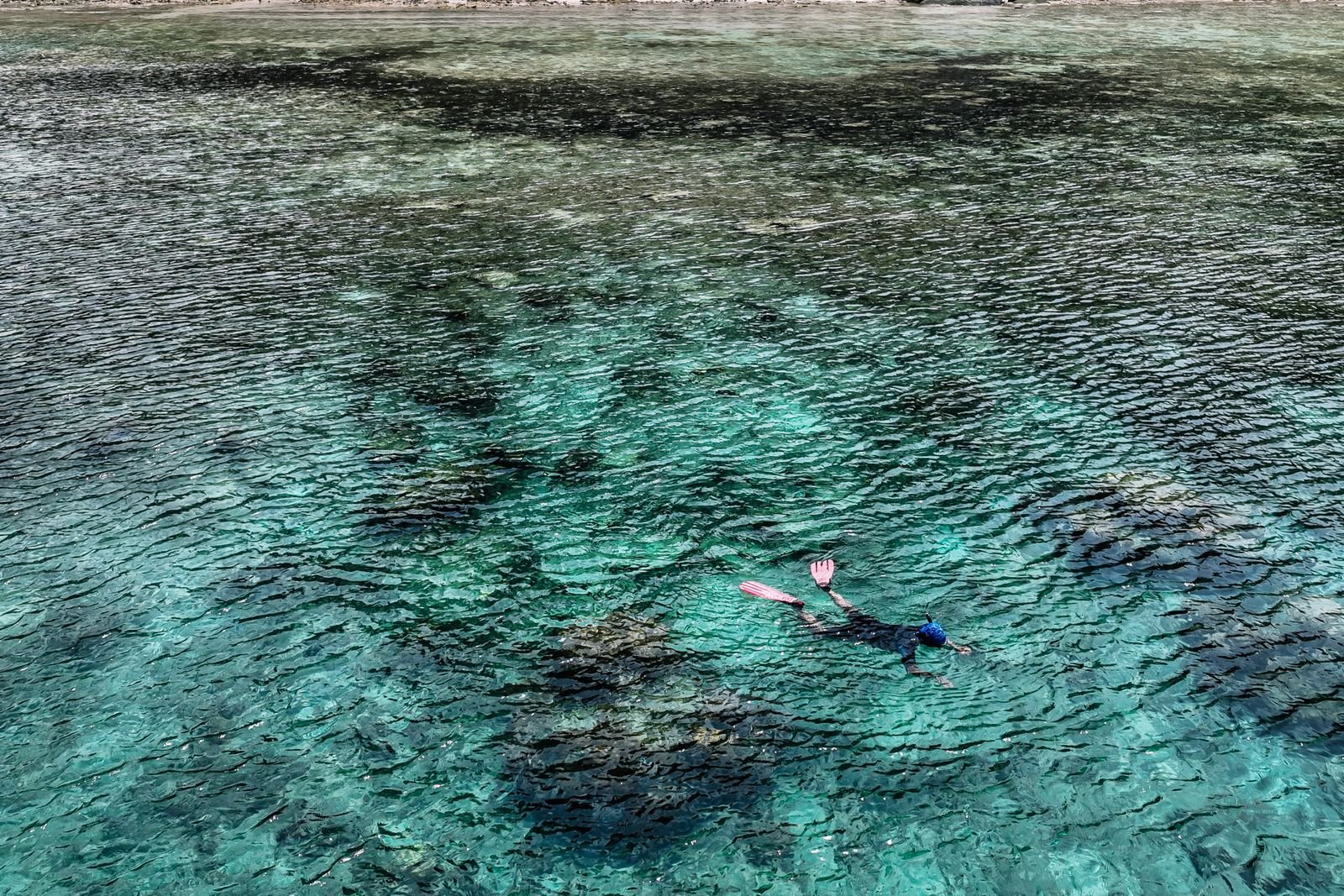 Snorkeler over a vibrant coral reef in turquoise water