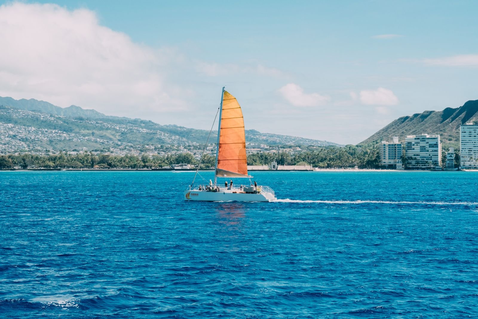 Catamaran full of friends on clear water