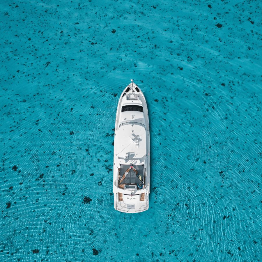 White yacht seen from above on clear turquoise water