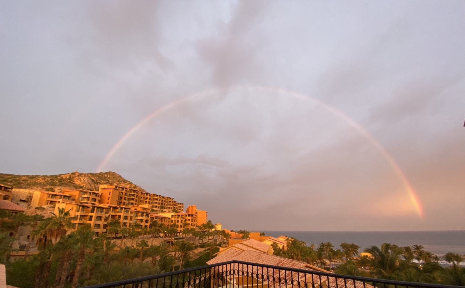 A rainbow over the desert mountains behind a Cabo San Lucas resort