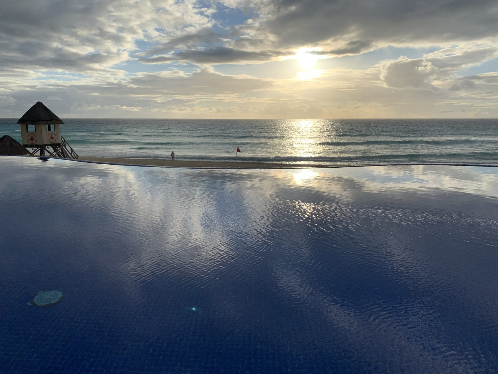 An infinity pool looking out over a lifeguard hut and the Caribbean Sea in Cancun