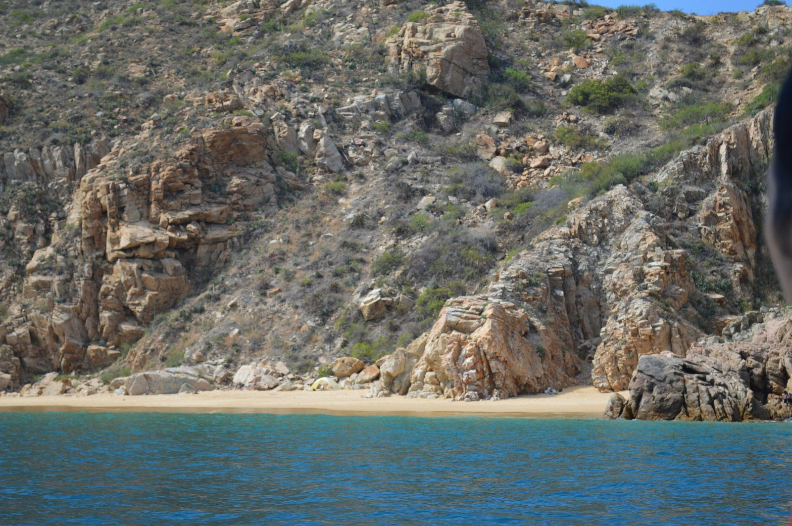 A small cove beach tucked under the rock faces at Land's End, Cabo San Lucas, seen from the water